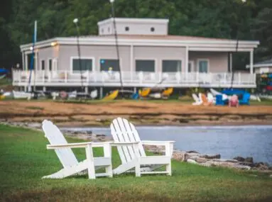 two white chairs on the shore