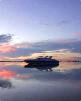 boat on calm water and sunset