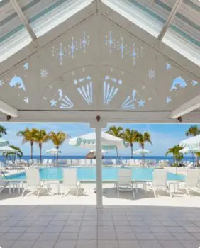 pool surrounded by white chairs