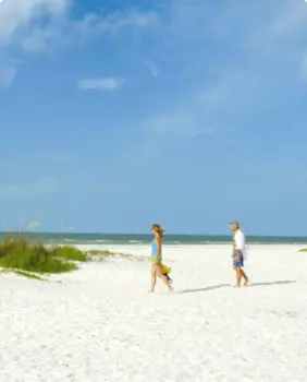 two people walking on a beach