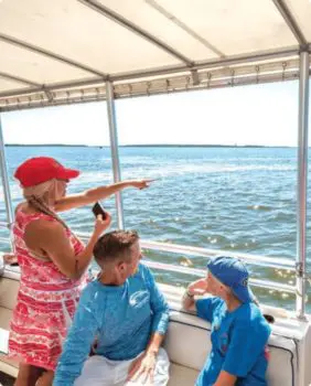 three people looking at the water from boat