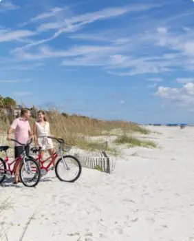 two people with bikes on beach
