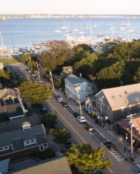 aerial view of street with houses and stores on it next to a marina