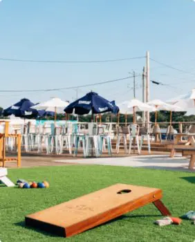corn hole with tables and chairs in the background