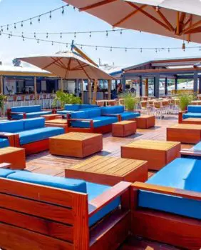 outdoor dining with blue couches and umbrellas