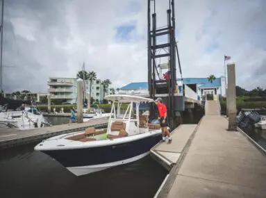 man holding onto a boat in a slip