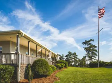 Home-like building with a lawn and flagpole with American flag