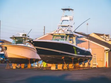 two fishing boats on hoists on land