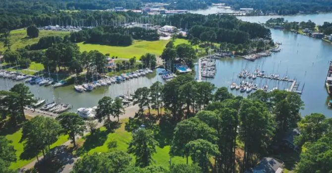 aerial view of channel with boats docked surrounded by trees