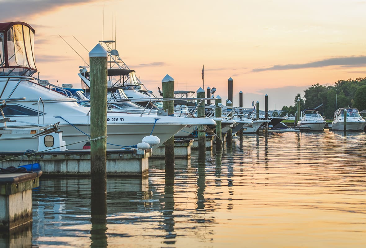 Boats docked at marina at sunset