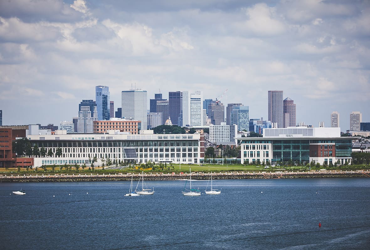 Boats sailing on water with city skyline in background