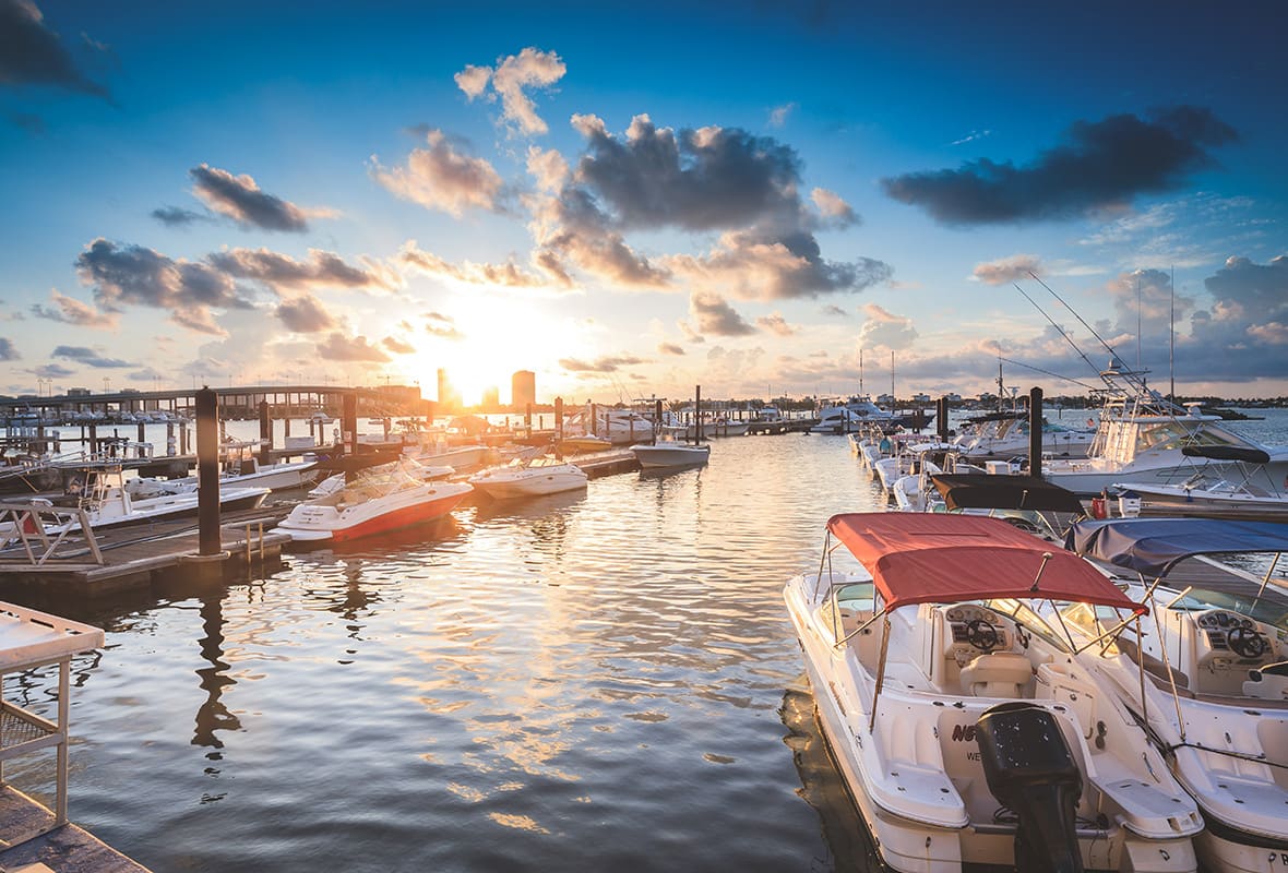 Boats docked at marina at sunset