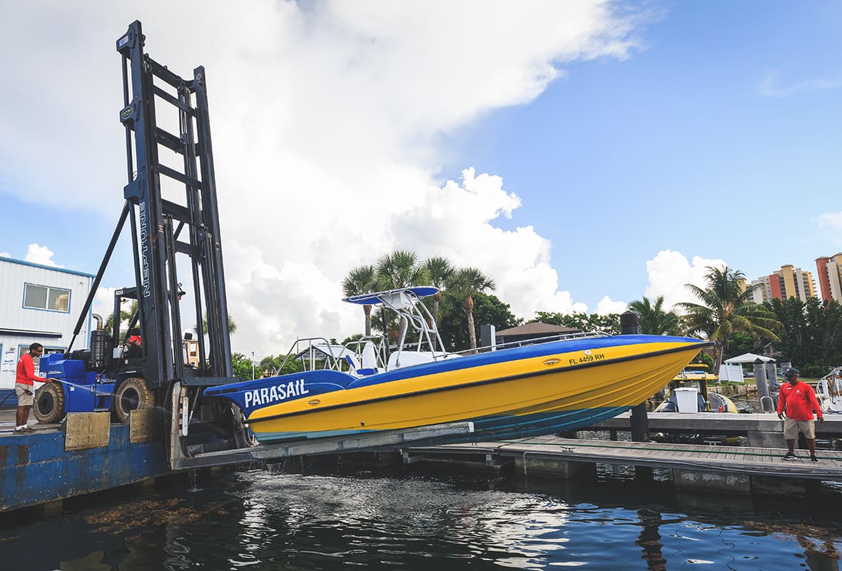 Boat being lifted down to water from storage