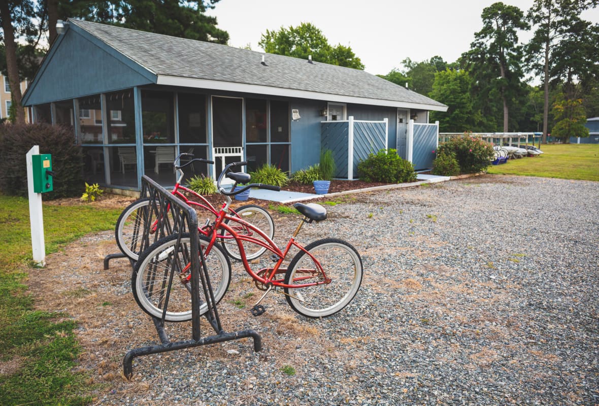 2 red bikes parked in front of a small building