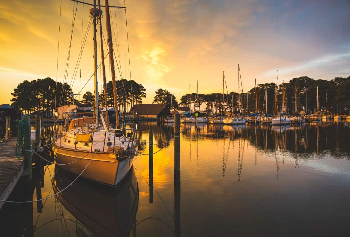 boats docked in a marina at sunset