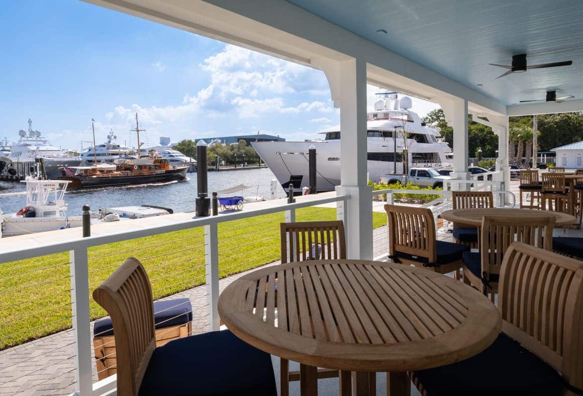 chairs and tables on a patio overlooking a marina