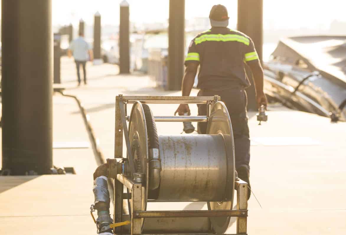 man pulling hose spool