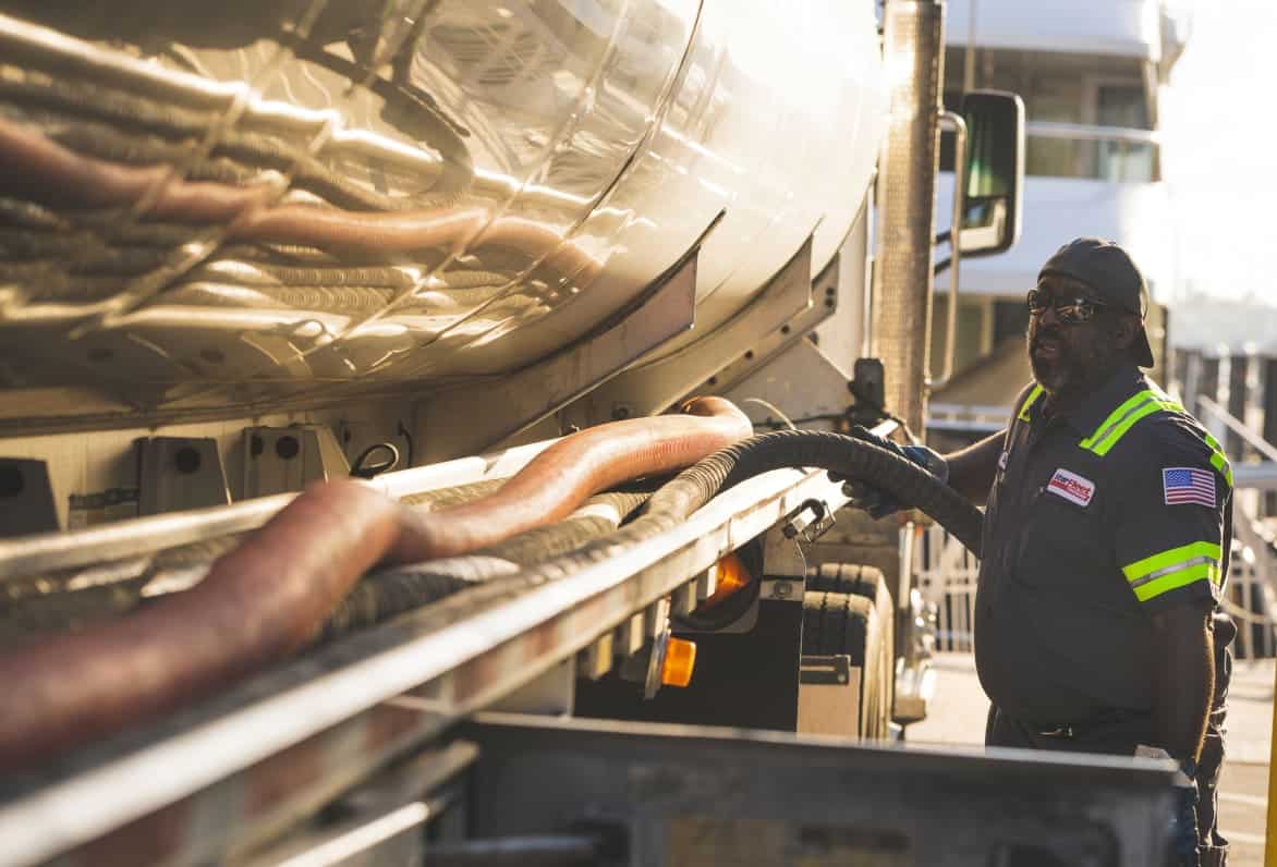 a man putting fuel into a semi truck