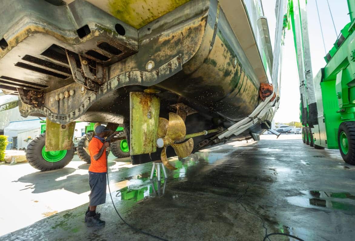 man underneath yacht servicing it