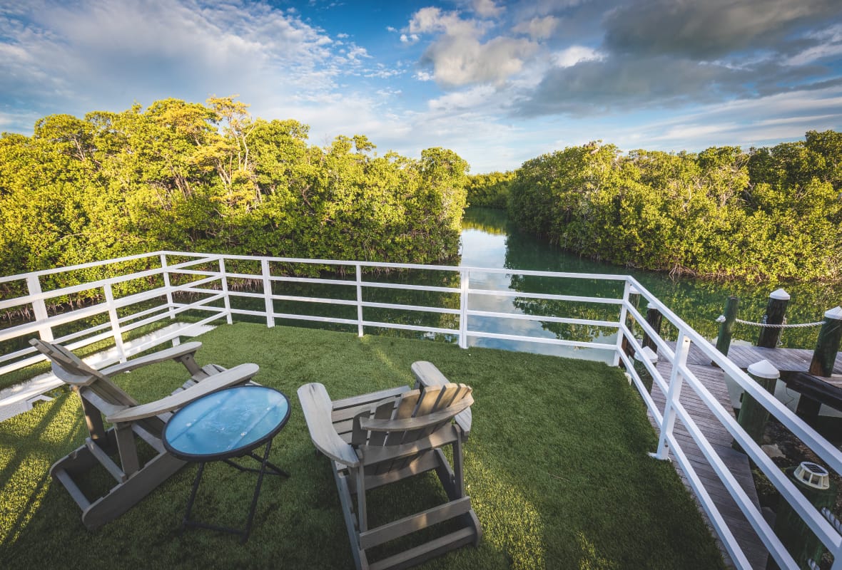 two chairs with a white fence around it looking out to water