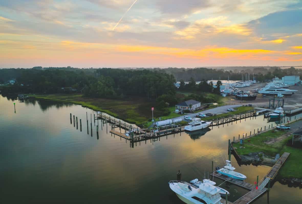 calm water surrounded by trees with sunset