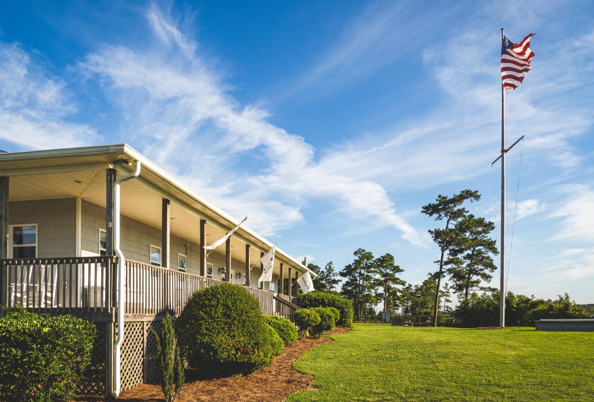 Home-like building with a lawn and flagpole with American flag
