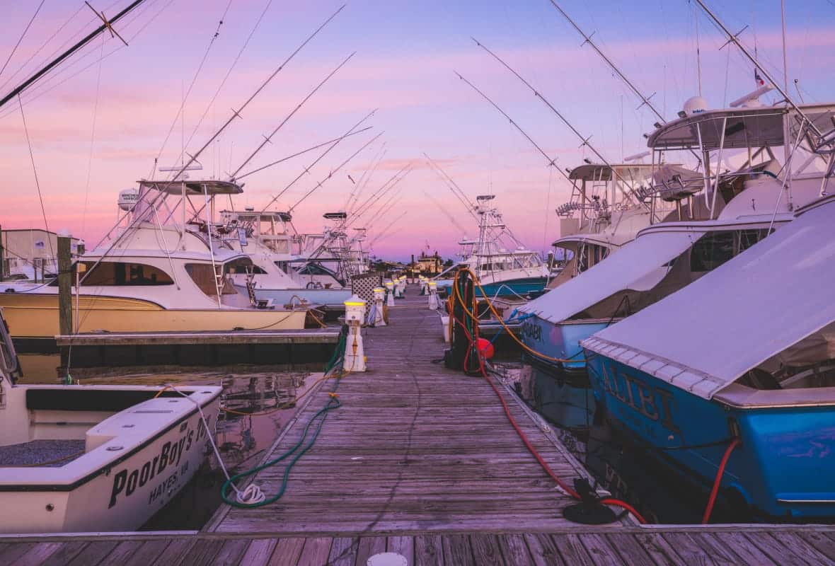 small boats docked with pink sunset haze