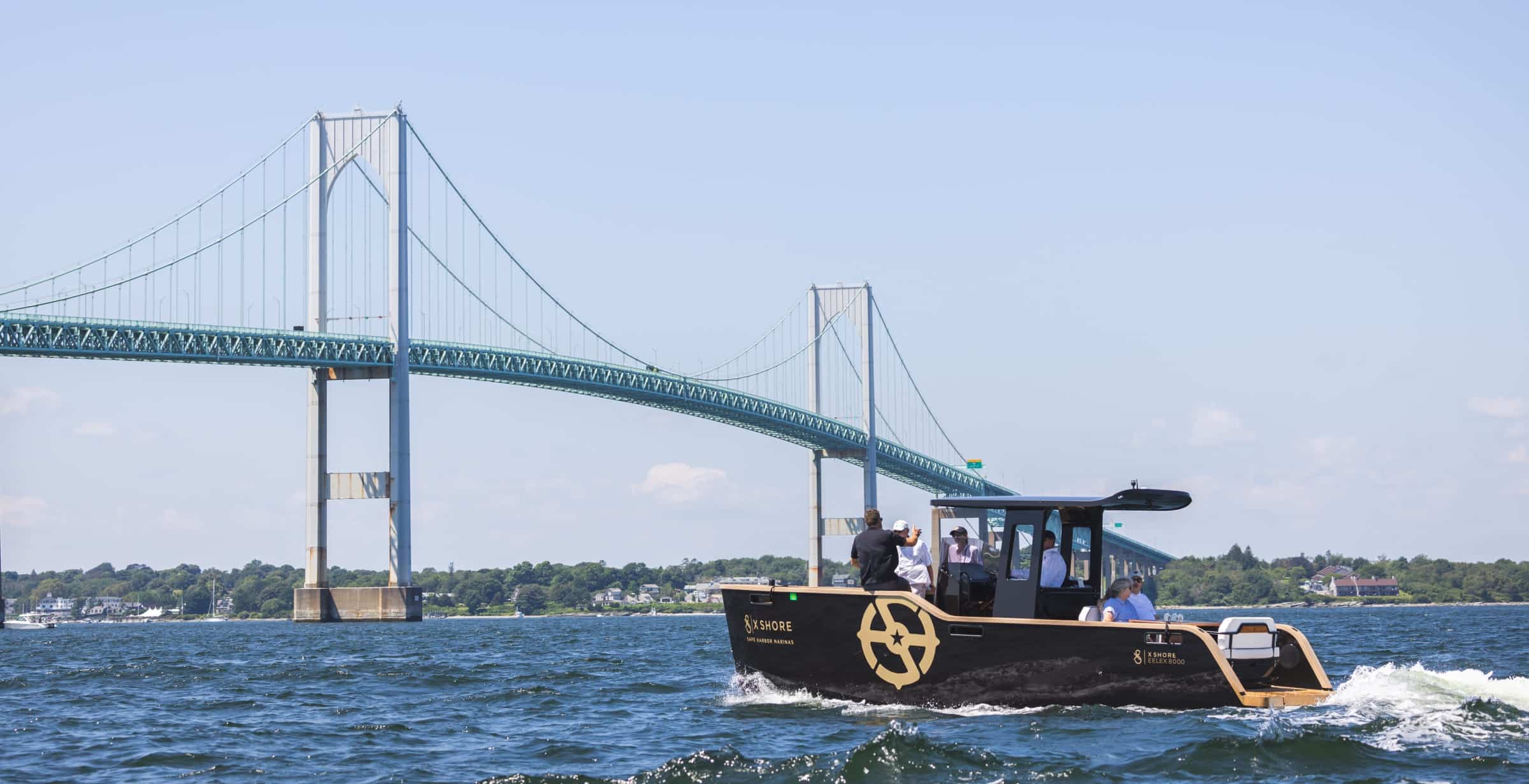 X Shore boat in the water with bridge in the background